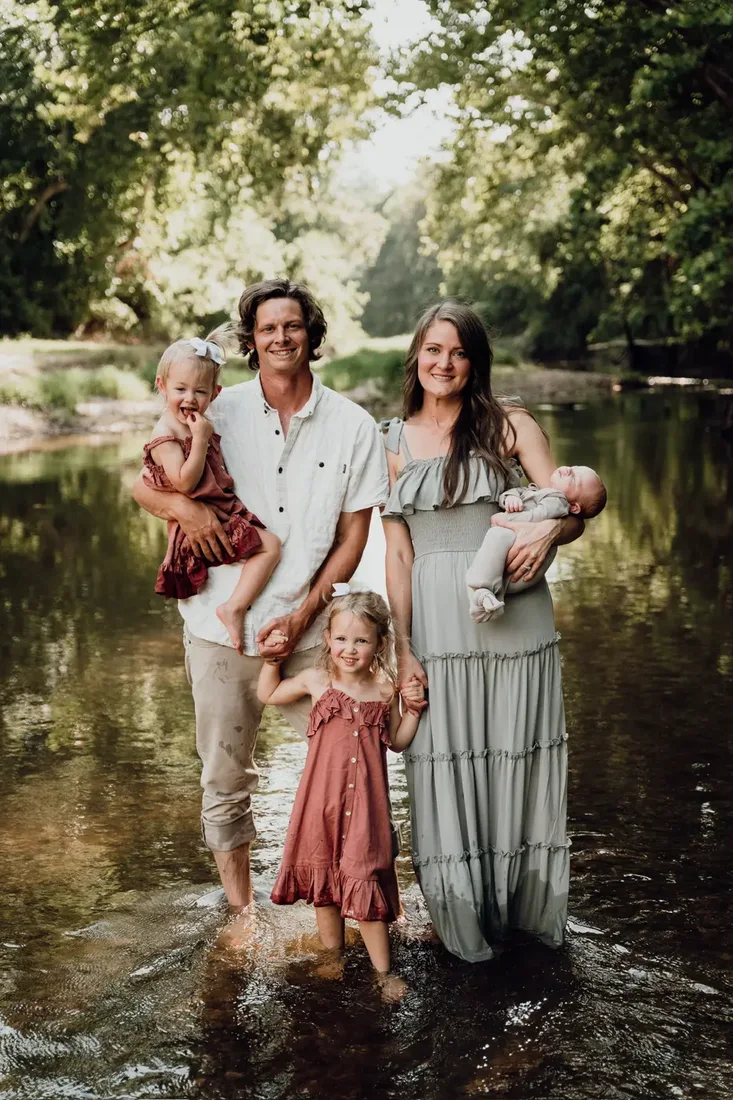 Family of five wading in a river together