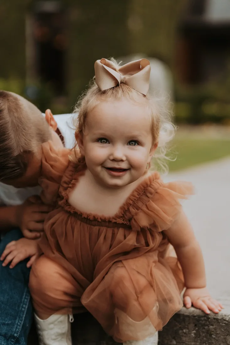 Toddler in a ruffled dress smiling