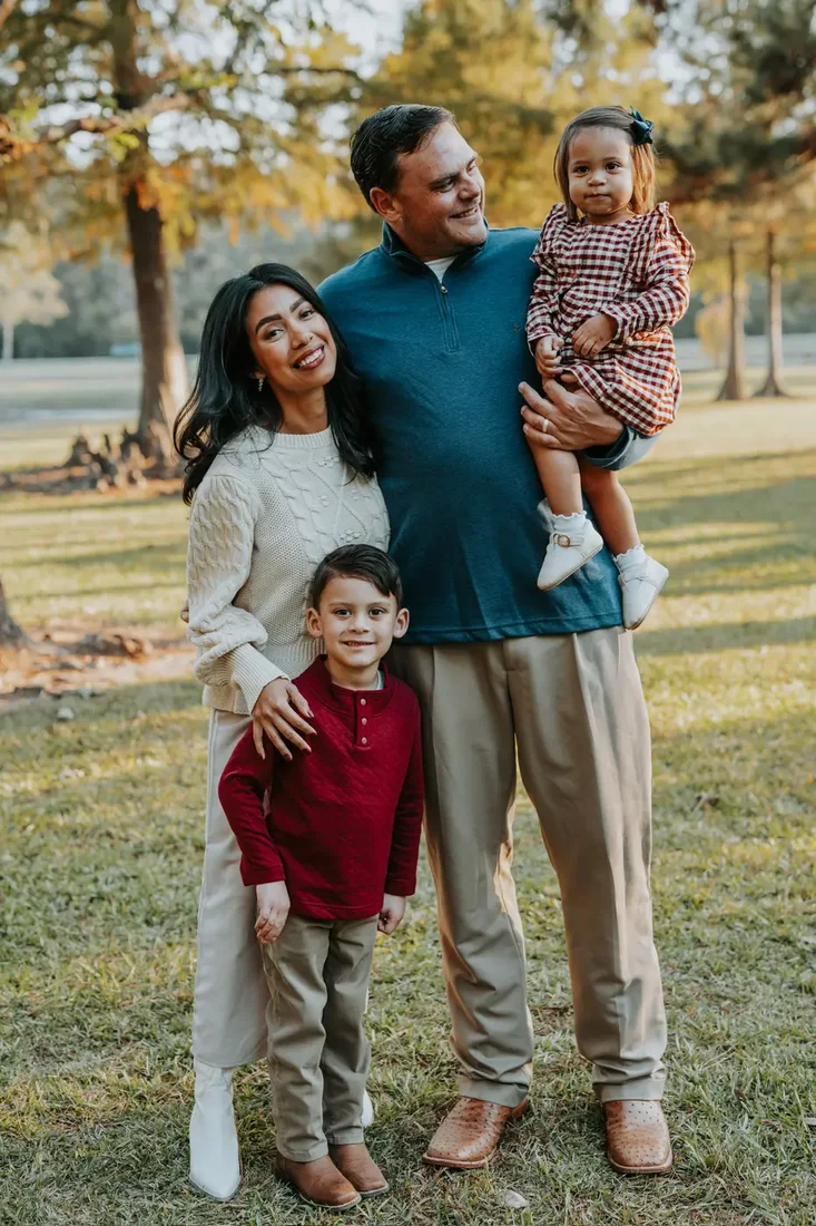 Family of four smiling together in the park