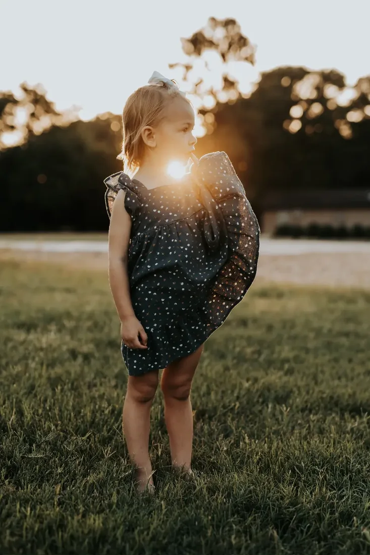 Little girl in a floral dress at golden hour