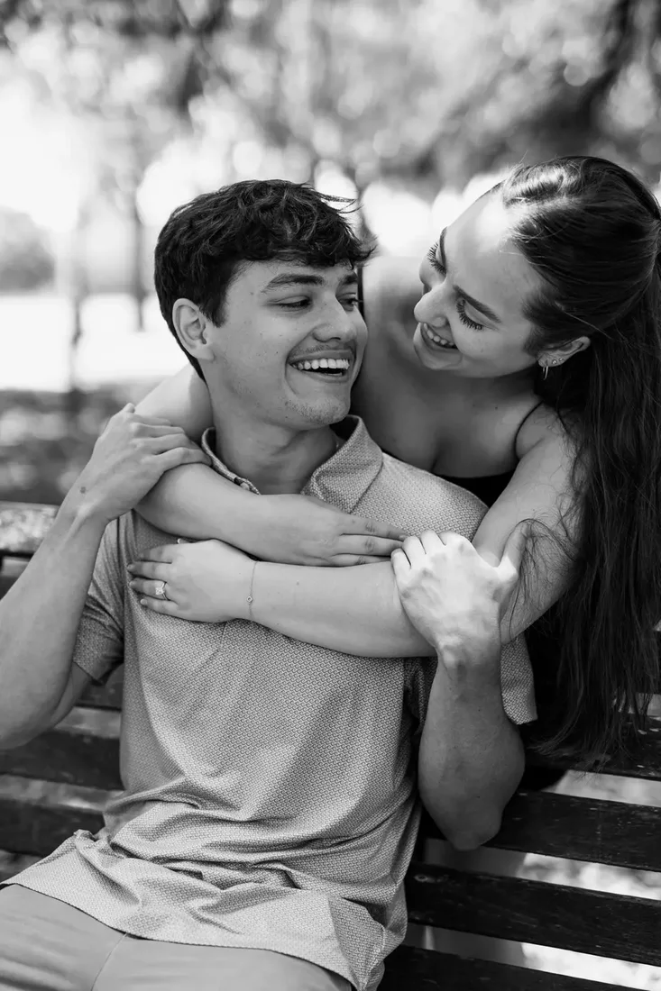 Engagement session, couple embracing on a park bench, black and white