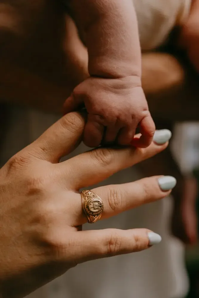 Newborn's hand wrapped around a parent's finger