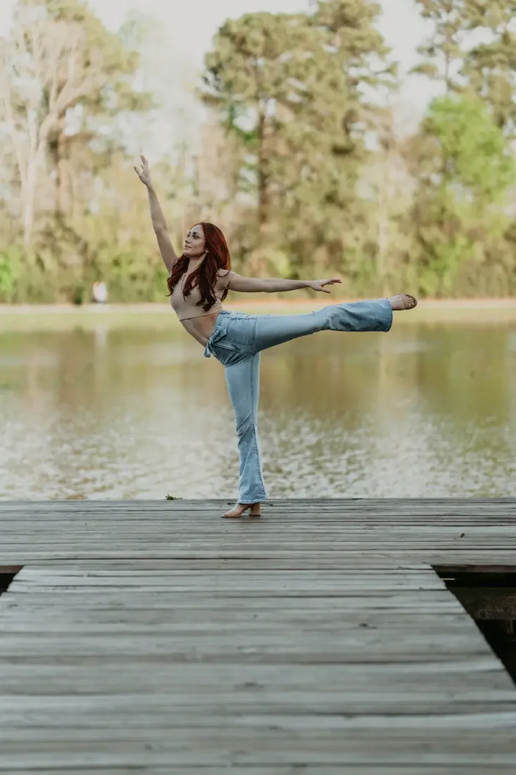 Senior portrait dancing on a dock by the water