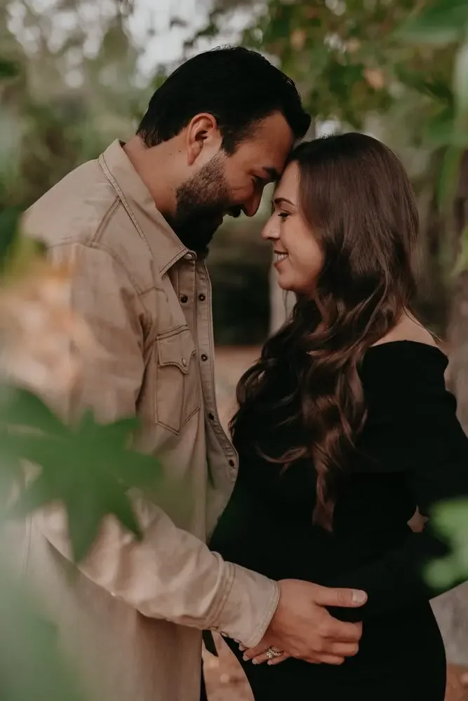 Expecting couple, foreheads together