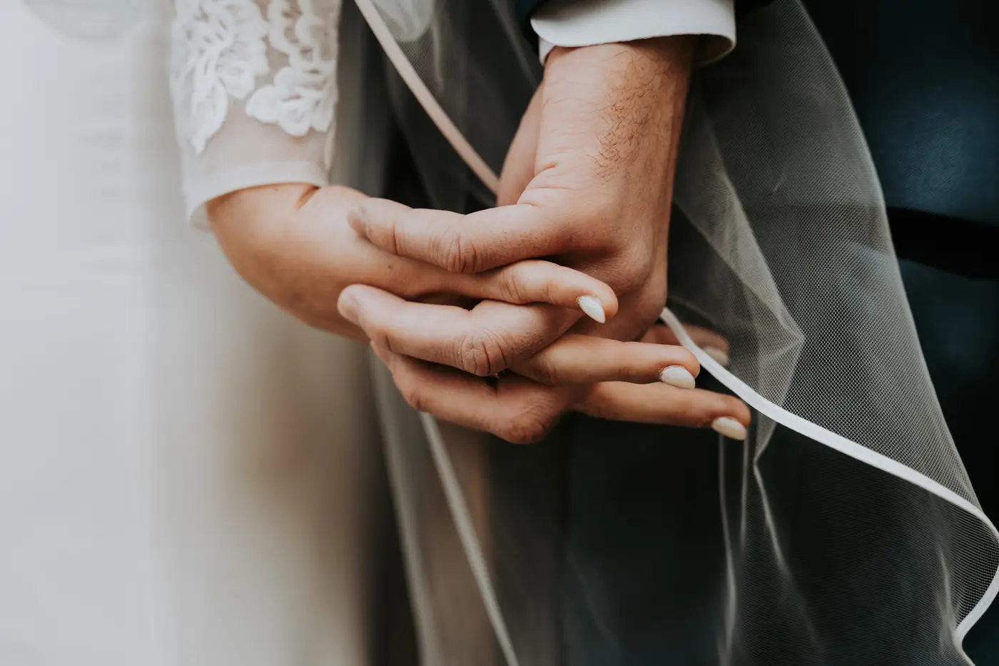 Bride and groom's hands clasped together, detail shot