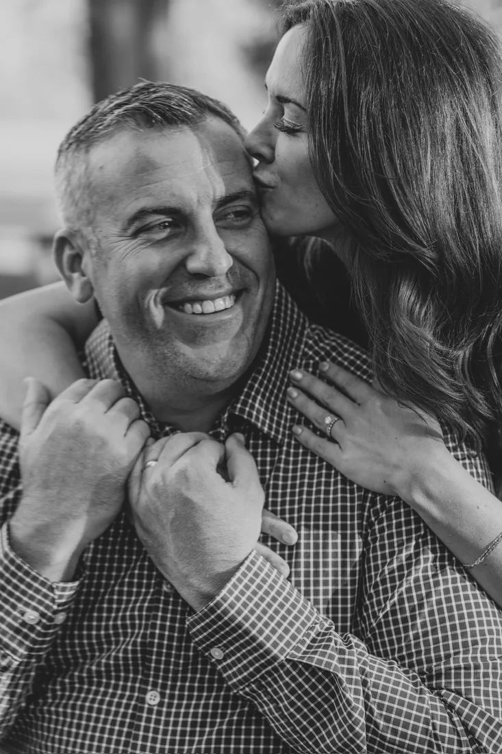 Couple sharing a tender kiss on the cheek, black and white