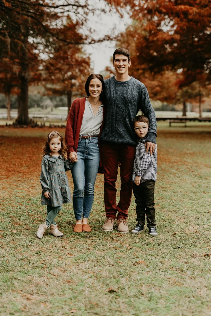 Family of four smiling together in autumn