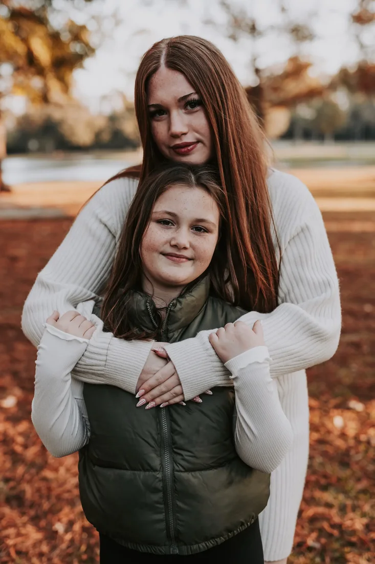 Two sisters embracing outdoors in autumn