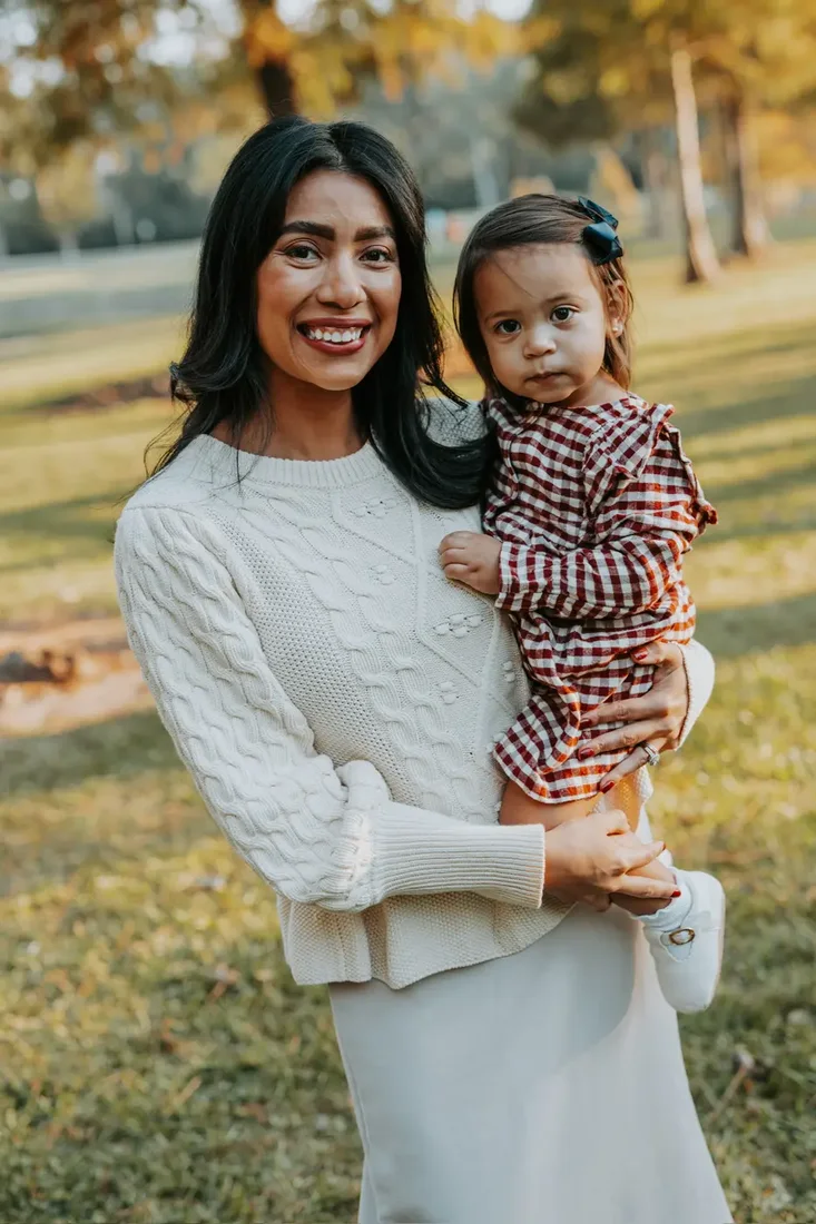 Mother holding her toddler daughter outdoors