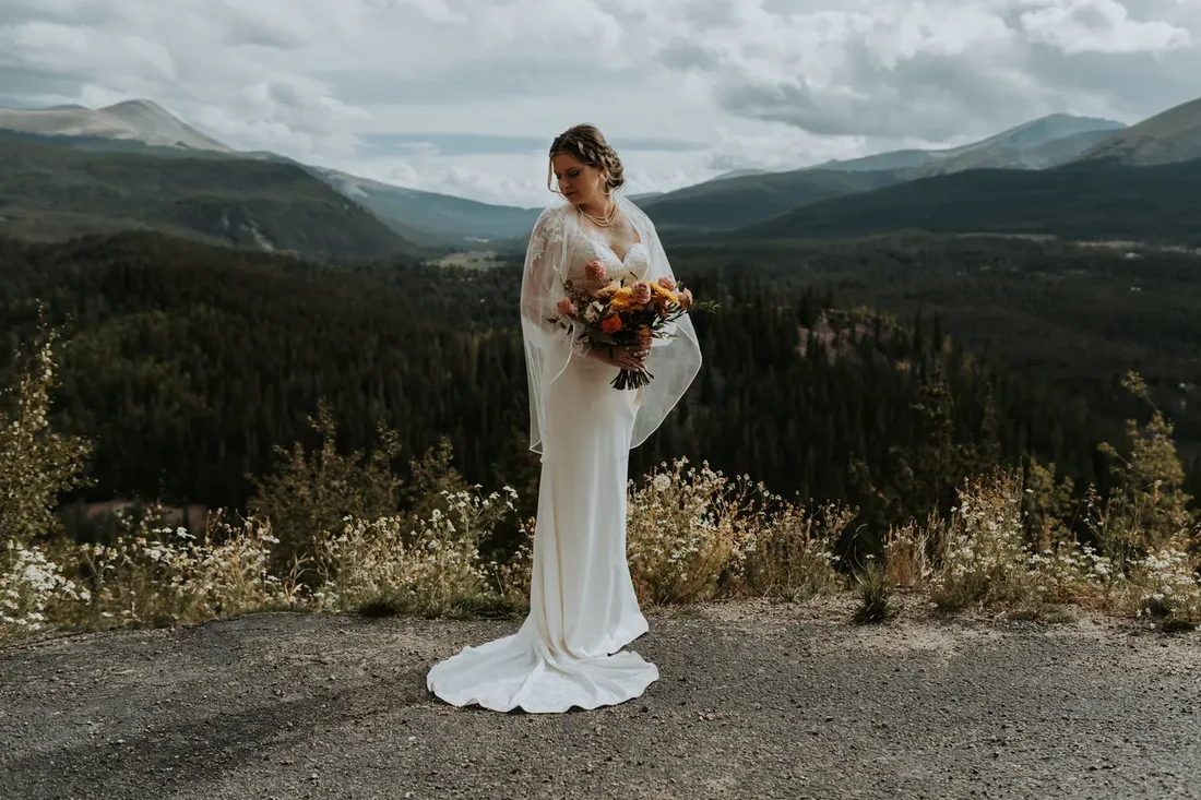 Bride standing alone with mountain views behind her