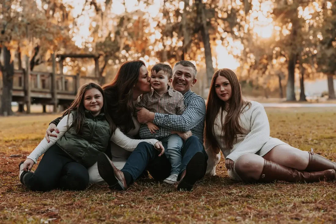 Three generations of a family sitting together at sunset