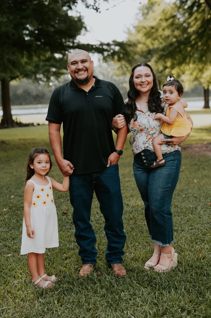 Family of four smiling in the park